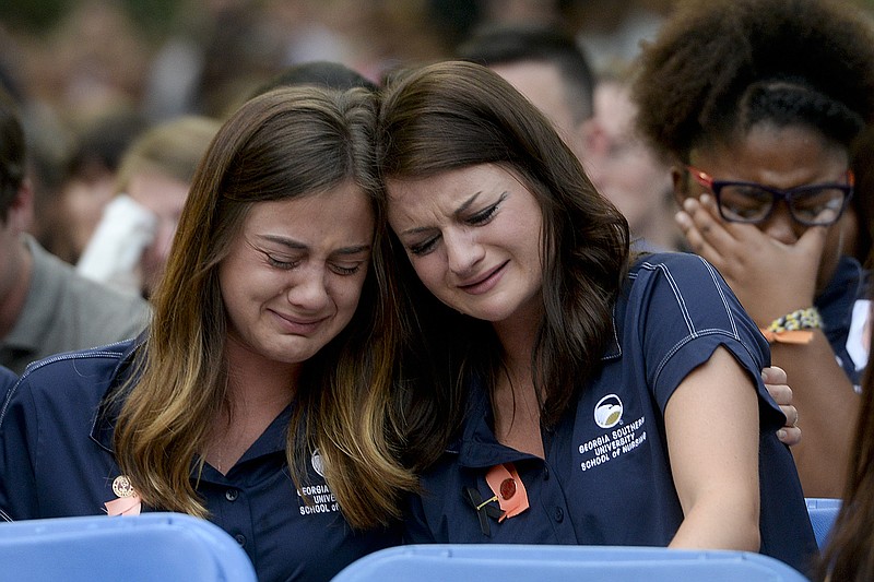 Members of the Georgia Southern Nursing program console one each during a candlelight vigil and memorial service for five nursing students who were killed in a multi-vehicle accident, Thursday, April 23, 2015, at Georgia Southern's Statesboro campus in Statesboro, Ga. 