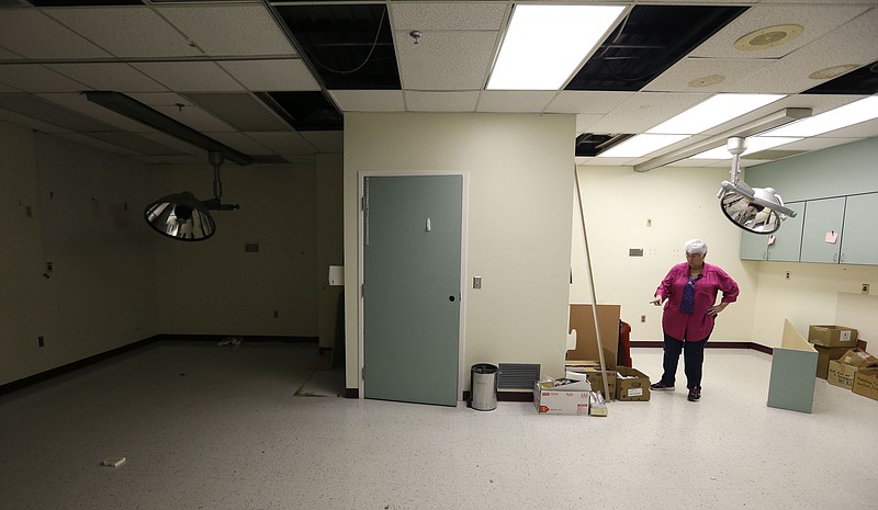 
              In this April 1, 2015, photo, Chris Smiley, the hospital's last chief executive, stands in the empty emergency room of Sac-Osage Hospital in Osceola, Mo.. After 45 years of providing health care in rural western Missouri, Sac-Osage Hospital is being sold piece by piece. (AP Photo/Orlin Wagner)
            