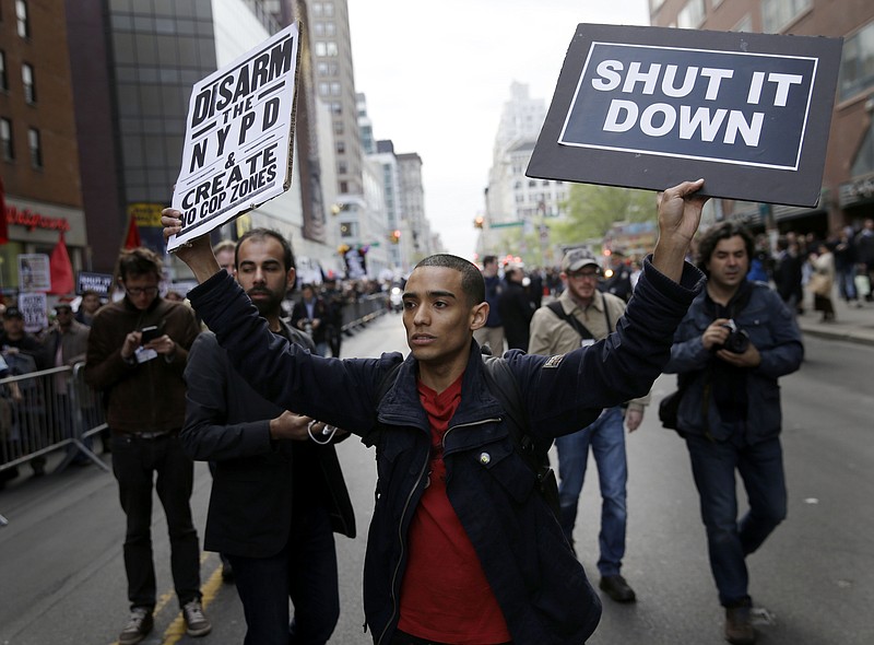 A protester walks outside of police barricades during a march in New York, Friday, May 1, 2015. 