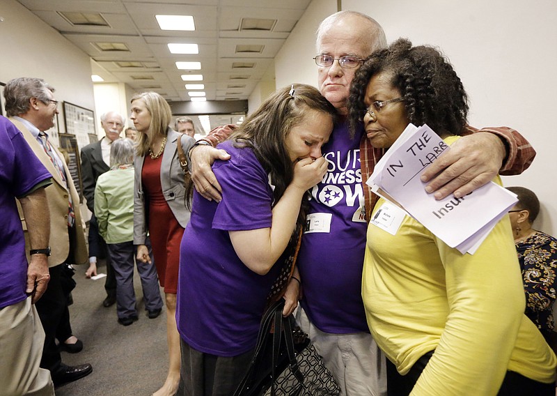 Larry Drain comforts Tracy Foster, left, of Clinton, Tenn., and Michele Fardan after Gov. Bill Haslam's Insure Tennessee proposal was voted down in the Senate Commerce Committee on March 31, 2015, in Nashville. 