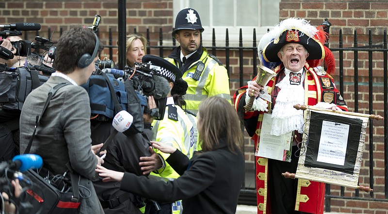 Tony Appleton, a town crier, announces to the assembled media the birth of the royal baby, outside the Lindo Wing, St. Mary's Hospital, London, Saturday, May 2, 2015. Kate, the Duchess of Cambridge, has given birth to a baby girl, royal officials said Saturday