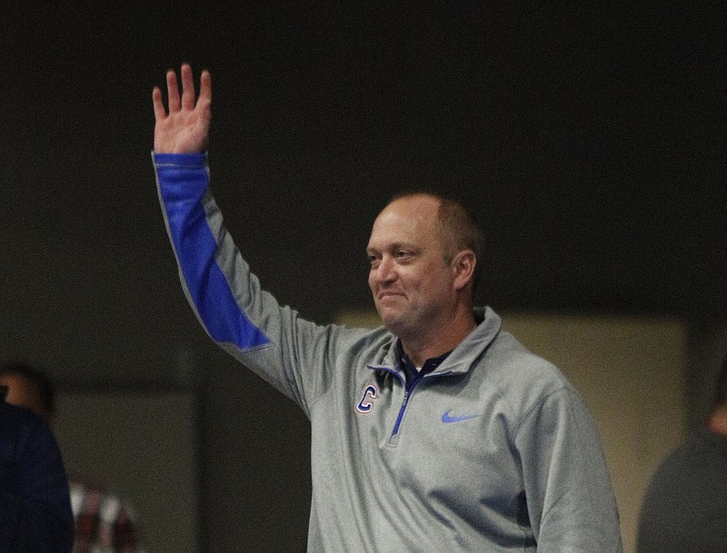 New Cleveland football coach Scott Cummings raids his hand as he is introduced before the Cleveland-Bradley Central high school wrestling meet Jan. 6, 2015, at Cleveland Middle School in Cleveland, Tenn.