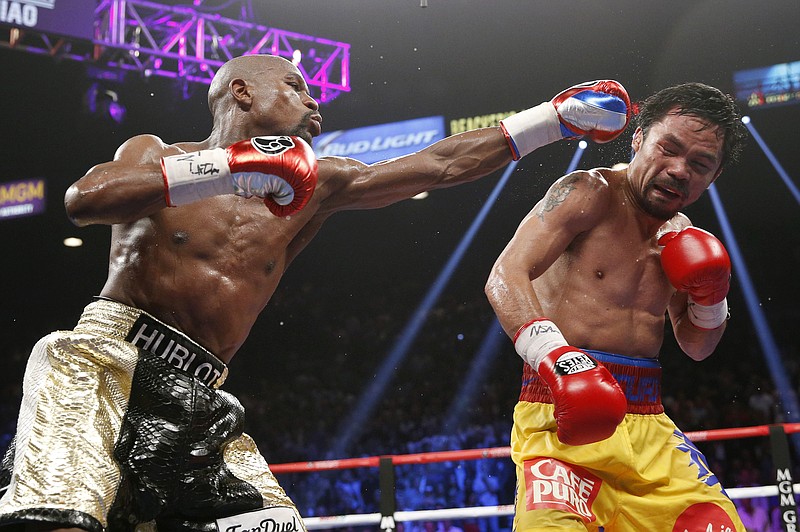 Floyd Mayweather Jr., left, hits Manny Pacquiao, from the Philippines, during their welterweight title fight in Las Vegas in this May 2, 2015 file photo, 