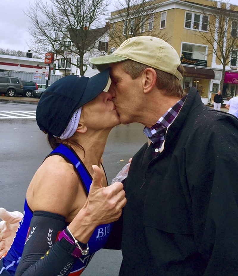
              In this April 20, 2015 photo provided by Paige Tatge, her mother, Barbara Tatge, left, kisses an unknown spectator in Wellesley, Mass., as she ran in the Boston Marathon. It's a tradition for male runners to kiss the women attending Wellesley College as they line the marathon route. Barbara made good on a dare by her daughter, Paige, that she kiss a man as she ran along the route. Now they would like to know who she actually kissed. (Paige Tatge via AP)
            