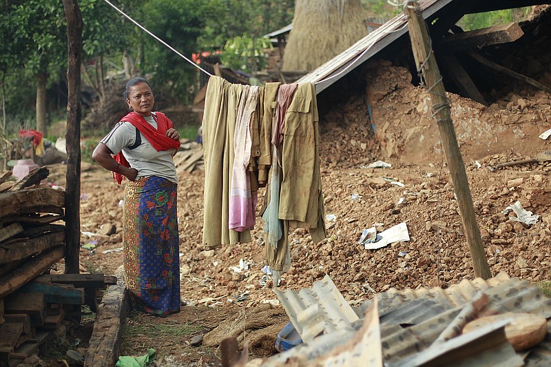 
              In this photo taken on Saturday, May 2, 2015, standing in the rubble of her home, Radha Shrestha, 42, strings a clothesline to hang laundry in the destroyed village of Pokharidanda, near the epicenter of the April 25 massive earthquake, in the Gorkha District of Nepal. People in villages reachable by road in Nepal’s quake-wracked central Gorkha District are fending for themselves, with the government so short on relief they’ve been forced to focus only on far-flung reaches of the remote Himalayas. (AP Photo/Wally Santana)
            