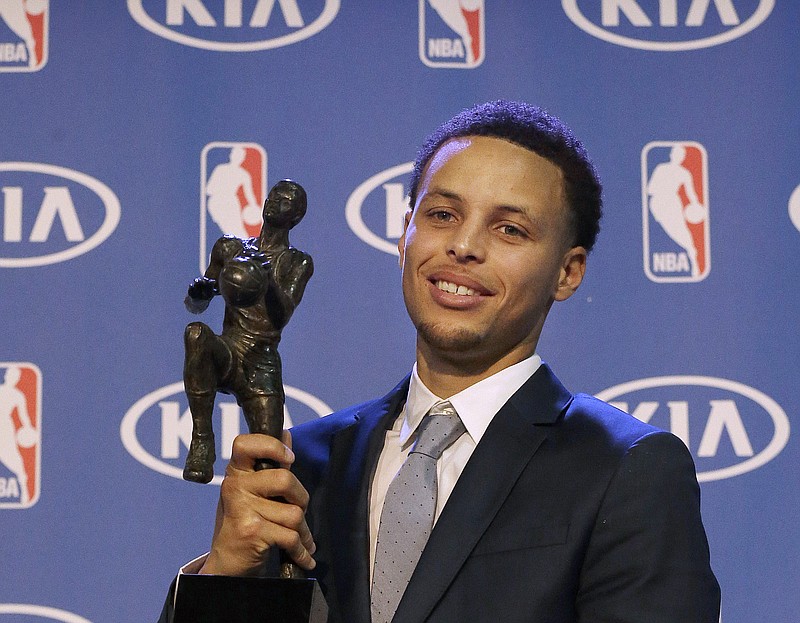 Golden State Warriors guard Stephen Curry holds the NBA's Most Valuable Player award at a basketball news conference Monday, May 4, 2015, in Oakland, Calif.
