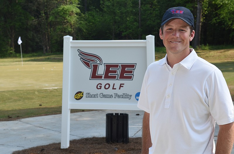 Lee University golf coach John Maupin stands in front of the sign at the short game practice facility at the Cleveland Country Club. 