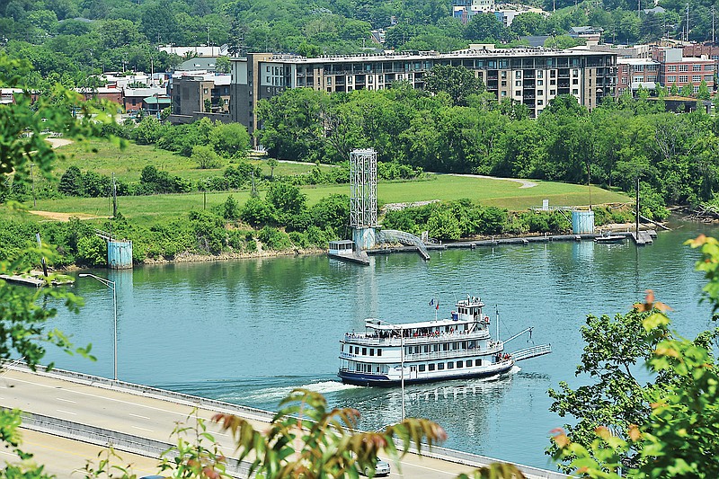 The Southern Belle riverboat moves upstream on the Tennessee River in this view of the North Shore land where businessman Allen Casey's barge formerly was located