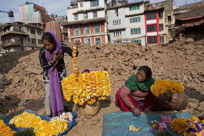 
              Nepalese flower vendors wait for customers at the Basantapur Durbar Square, damaged in the April 25 earthquake in Kathmandu, Nepal, Tuesday, May 5, 2015. Nepal is one of the world's poorest nations, and its economy, largely based on tourism, has been crippled by the earthquake, which left thousands dead. (AP Photo/Bernat Amangue)
            