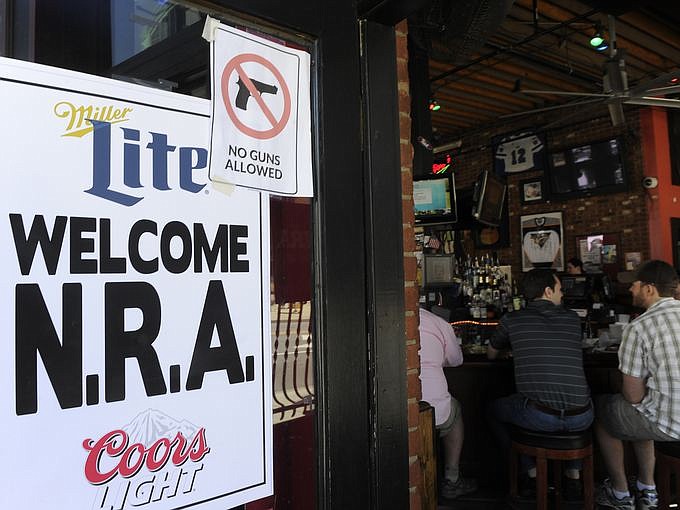 Several bars along Broadway posted signs welcoming NRA members and some bars also posted no guns allowed. (Photo: Shelley Mays/The Tennessean)