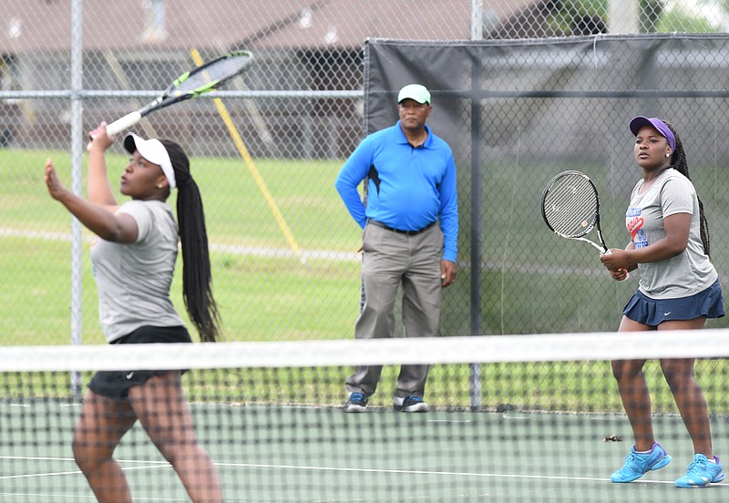 Brainerd tennis coach Alphonso Canty watches his no. 1 doubles team, Brittney Canty, right, and Brianna Canty play their way to another District 6-A/AA title at the Brainerd Recreation Center courts on April 29, 2015.