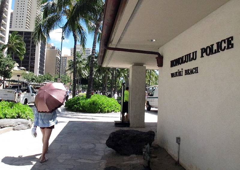 A pedestrian walks in front of a Honolulu Police Department station in Honolulu's tourist area of Waikiki in this file photo. 