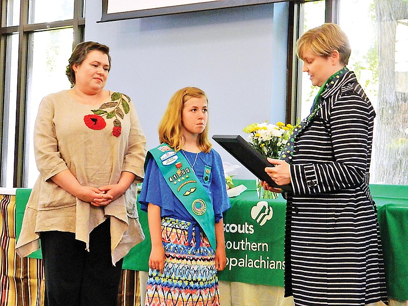 Booth Kammann, right, CEO for the Girl Scouts' Council of the Southern Appalachians, awards the Girl Scout Medal of Honor to AnnaLee Simpson, center. AnnaLee received the honor in recognition of efforts she made to save her mother, Jackie, left, during a medical emergency last summer.