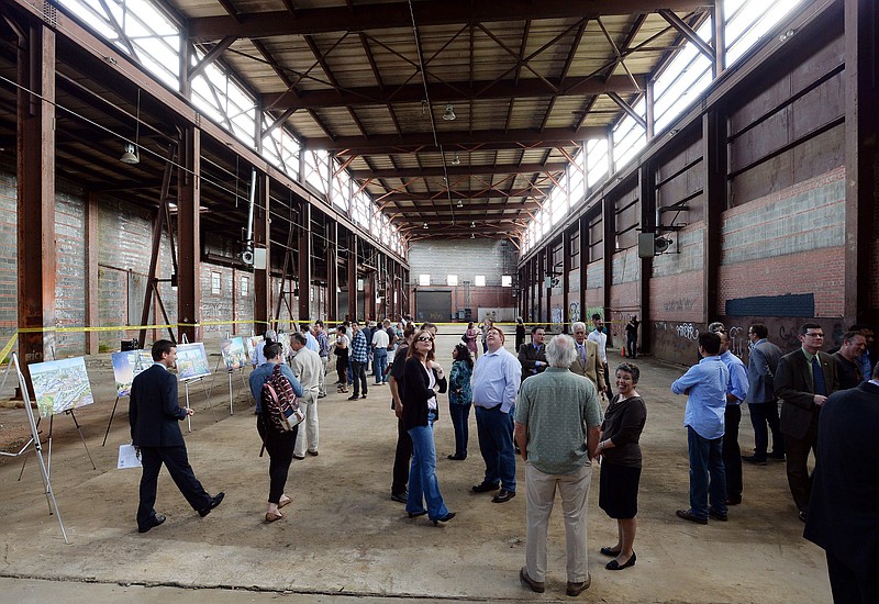 
              Attendees check out the interior of the former Dillon Supply Company warehouse at 510 W. Martin Street in Raleigh, NC, Friday May, 8, 2015 after a groundbreaking ceremony.  Raleigh Union Station will be home to the new Amtrak station sometime in 2017. The nation's top transportation official says he's more optimistic that high-speed rail will eventually become a reality in the Southeast after Georgia and South Carolina expressed interest in a joint agreement between North Carolina and Virginia to study, coordinate and advocate for the project. (Chuck Liddy/The News & Observer via AP)
            
