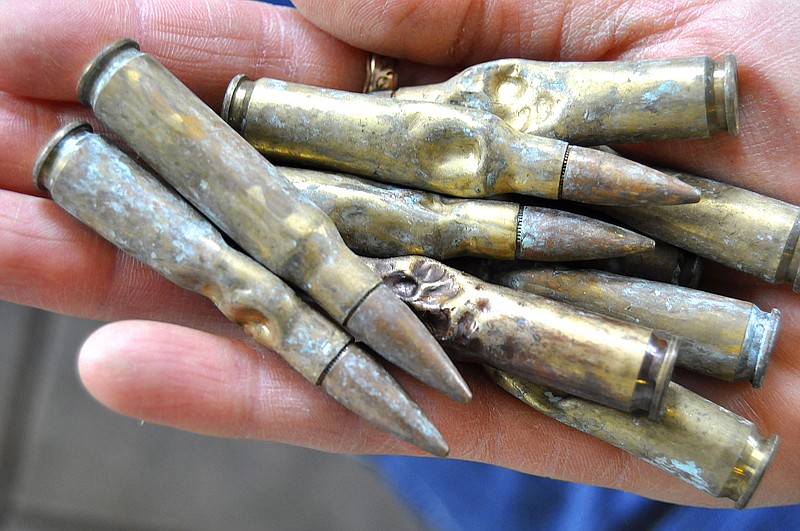 In this photo taken April 27, 2015, in Mountain Home, Ark., dog owner Sonny Brassfield holds nine of the 23 live .308 caliber rifle rounds his Belgian Malinois "Benno" chewed and swallowed. The dog is expected to fully recover from the two-hour surgery to remove the rounds. (Josh Dooley/The Baxter Bulletin via AP) NO SALES; MANDATORY CREDIT