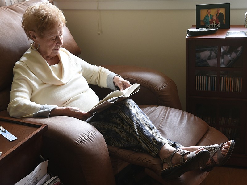 Millie Reis, age 86, reads a book in a recliner in her North Shore apartment on April 28, 2015.