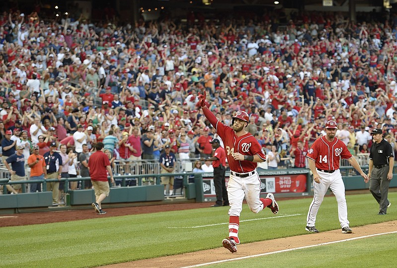 Washington Nationals' Bryce Harper gestures as he heads home after he hit a two-run walk-off home run during the ninth inning of their game against the Atlanta Braves, Saturday, May 9, 2015, in Washington. The Nationals won 8-6. 