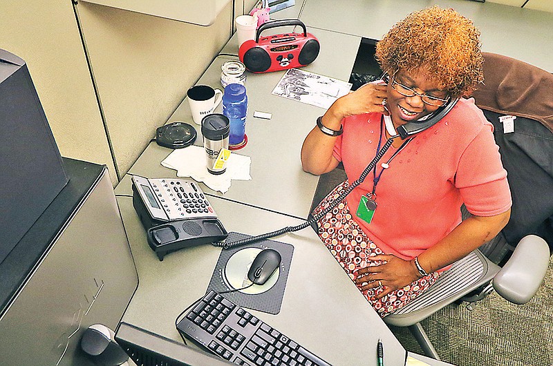 Tawana Hinton, CHA Housing Choice Voucher specialist, answers phones. Hinton's position was cut due to funding restrictions a couple of years ago but was recently brought back to the agency.