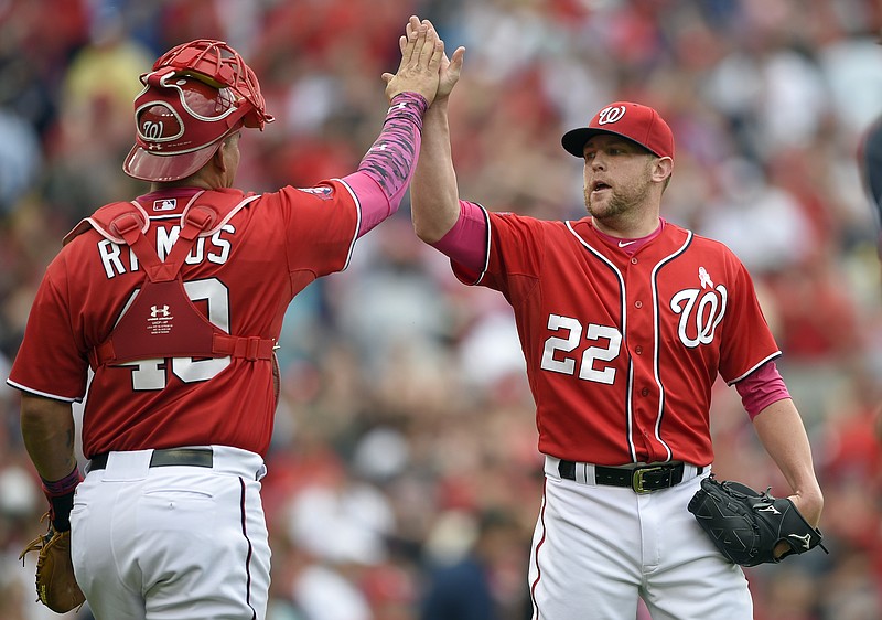 Washington Nationals relief pitcher Drew Storen (22) celebrates a 5-4 win over the Atlanta Braves with catcher Wilson Ramos (40) after a baseball game, Sunday, May 10, 2015, in Washington. 