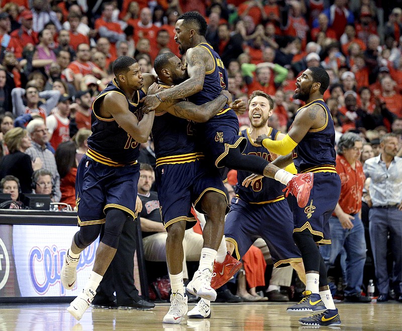 Cleveland Cavaliers' LeBron James, second from left, celebrates with Tristan Thompson, left, J.R. Smith, center, Matthew Dellavedova, and Kyrie Irving, right, after scoring the game-winning basket in Game 4 in a second-round NBA basketball playoff series against the Chicago Bulls in Chicago on Sunday, May 10, 2015. The Cavaliers won 86-84. 