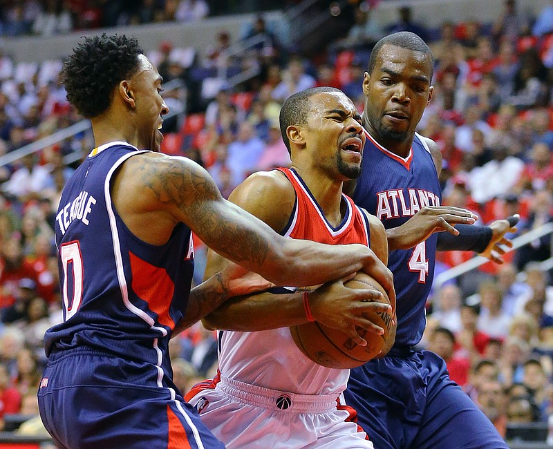 Atlanta Hawks Jeff Teague, left, and Paul Millsap, right, double team Washington Wizards' Ramon Sessions during the first half of Game 4 of the second round of the NBA basketball playoffs Monday, May 11, 2015, in Washington.