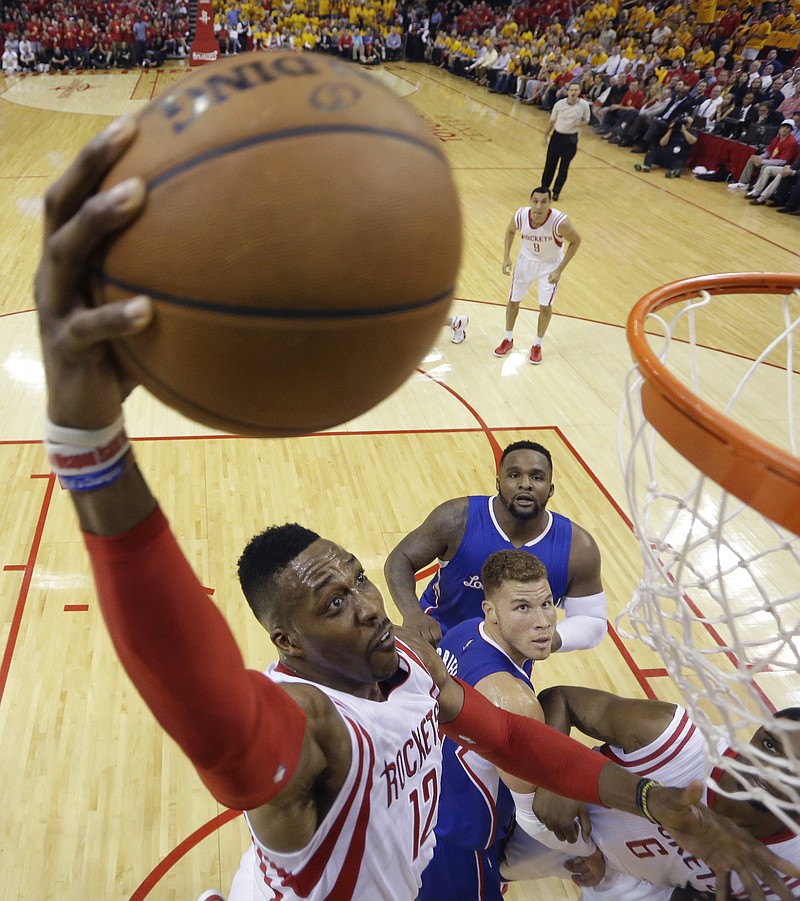 
              Houston Rockets' Dwight Howard (12) drives to the basket over Los Angeles Clippers' Blake Griffin, center bottom, and DeAndre Jordan, center top, during the first half in Game 5 of the NBA basketball Western Conference semifinals Tuesday, May 12, 2015, in Houston. (AP Photo/David J. Phillip)
            