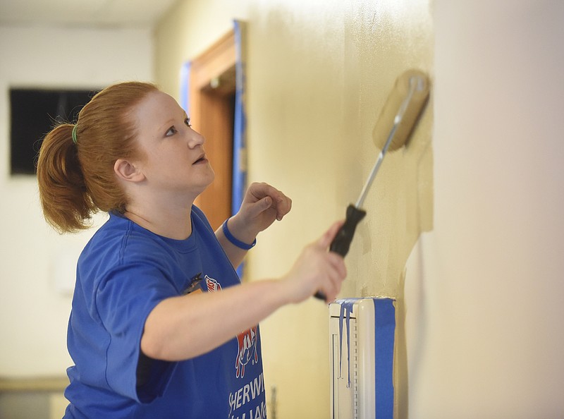 Sherwin-Williams employee Jennifer Lawrence paints the second-floor kitchen Tuesday morning at the Ronald McDonald House.