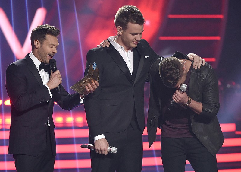 Clark Beckham, center, and Nick Fradiani, right, react after host Ryan Seacrest announces Fradiani as the winner at the American Idol XIV finale at the Dolby Theatre on Wednesday, May 13, 2015, in Los Angeles.