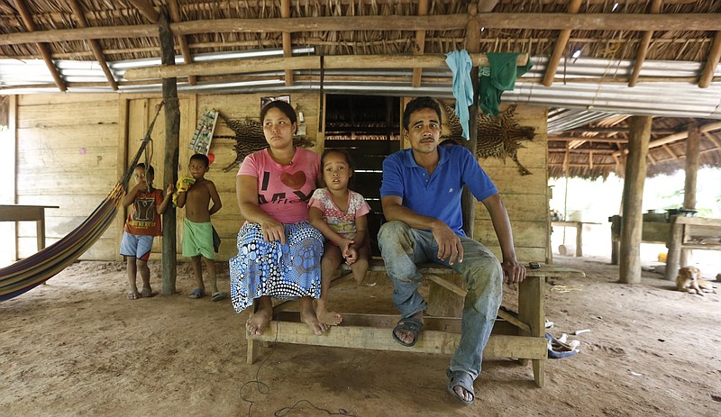 Joani Londono, 5, front center, sits between of her father Pio V Londono, right, and her mother, Edith Diaz at their home in Crucito, in Colombia's northwestern state of Cordoba in this May 11, 2015 photo. Joani's mother claims the girl was born premature with a club foot and a missing leg and she started to have pregnancy problems after she ate vegetables from a plot fumigated with chemicals from a plane. 