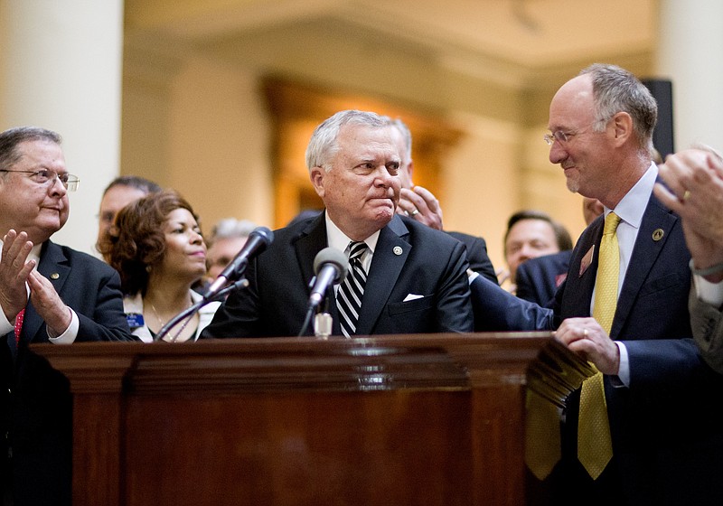 Georgia Gov. Nathan Deal, center, fights back tears while speaking after signing a medical marijuana bill into law as the bill's sponsor, Rep. Allen Peake, R-Macon, right, looks on during a ceremony at the Statehouse Thursday, April 16, 2015, in Atlanta.