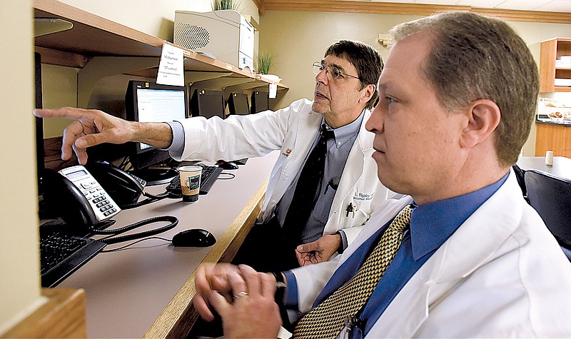 Drs. Stephen Adams, right, and Larry Rigsby discuss the way to enter patient information into Erlanger's current system.