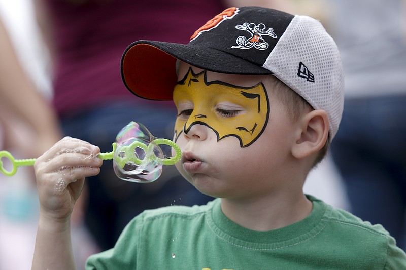 Landon Pelt blows bubbles at a booth at the annual Down Home Days celebration on Saturday, May 16, 2015, in Chickamauga, Ga. The celebration included inflatables, craft vendors, and a parade.