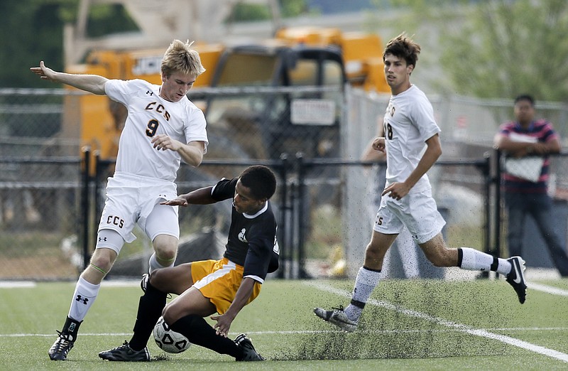 CCS's Porter Black, left, fights for control of the ball with Hixson's Micah Robinson, center, as CCS teammate Barrot Bickley covers behind during their boys' state soccer sectional match Saturday, May 16, 2015, at Chattanooga Christian School.