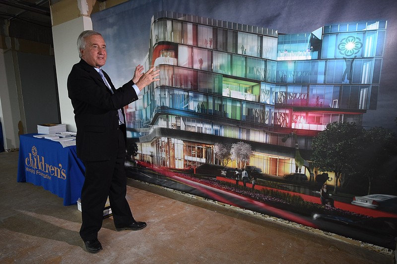 Bruce K. Komiske, project executive for Erlanger, stands on May 14, 2015, in front of a mural rendering of the new Children's Hospital that is scheduled to move across East Third Street creating a new look to the current campus.