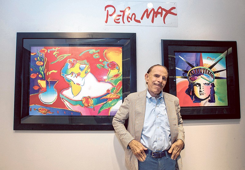Peter Max stands with is art.
