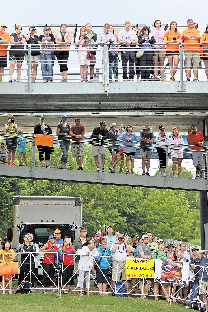 Spectators watch and shout encouragement as athletes transition from swimming to biking during the inaugural Sunbelt Bakery Ironman 70.3 Chattanooga race on Sunday, May 17, 2015.