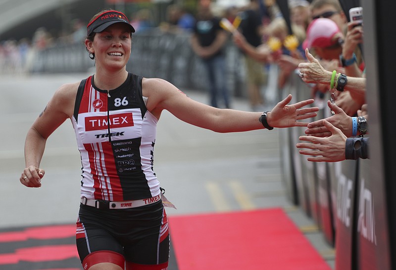 Professional athlete Jackie Hering #39 gives high fives while making her way into the finish line to take second place in the inaugural Sunbelt Bakery Ironman 70.3 Chattanooga race on Sunday, May 17, 2015.