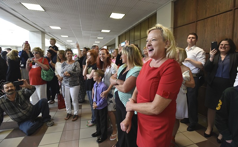 Judge Rebecca Stern laughs as she watches drug court graduates, participants and staff dance to the song "Uptown Funk" in the courthouse lobby after drug court graduation in Judge Stern's courtroom.