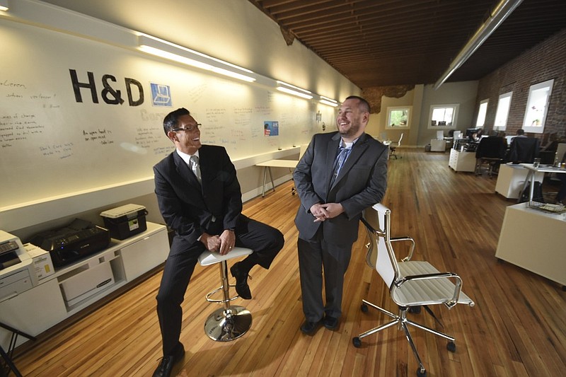 Heiko S. Juerges, left, president and CEO of H&D Corp., enjoys a moment with Brandon S. Miller, vice president-Business Development inside their new East Seventh and Market streets offices in downtown Chattanooga.