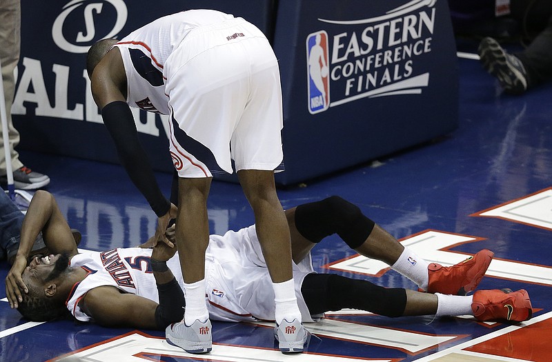 
              Atlanta Hawks forward DeMarre Carroll lies on the court as Atlanta Hawks forward Paul Millsap (4) speaks after Carroll was injured against the Cleveland Cavaliers during the second half in Game 1 of the Eastern Conference finals of the NBA basketball playoffs, Wednesday, May 20, 2015, in Atlanta. (AP Photo/David Goldman)
            