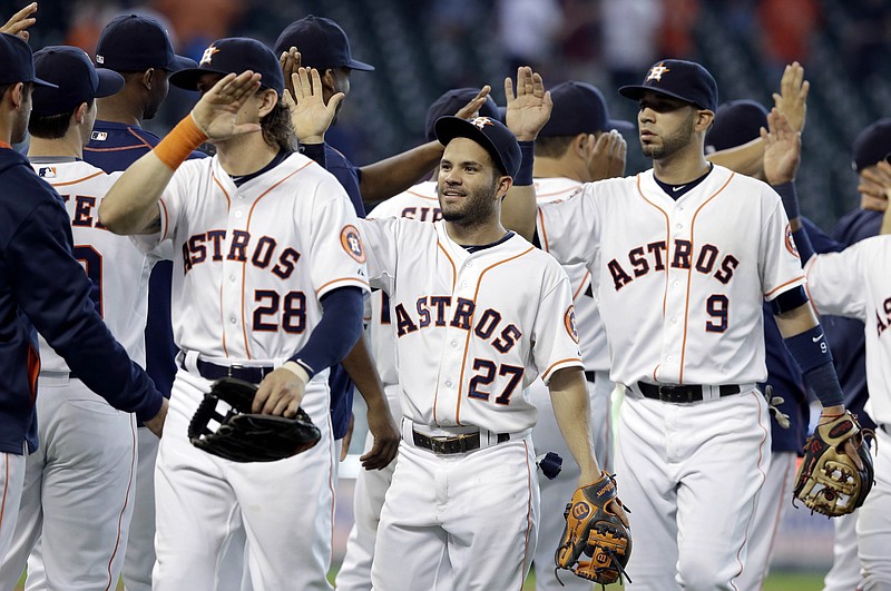 
              Houston Astros Colby Rasmus (28), Jose Altuve (27) and Marwin Gonzalez celebrate their 6-1 win over the Oakland Athletics in a baseball game Wednesday, May 20, 2015, in Houston. (AP Photo/Pat Sullivan)
            