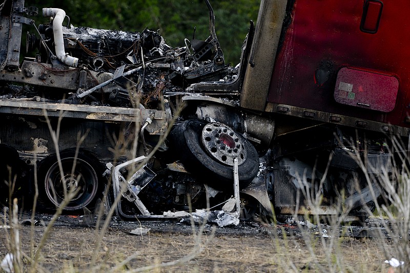 A tractor trailer sits on top of a crushed car after a multiple car accident on I-16 in Pooler, Ga. on Tuesday, May 19, 2015.