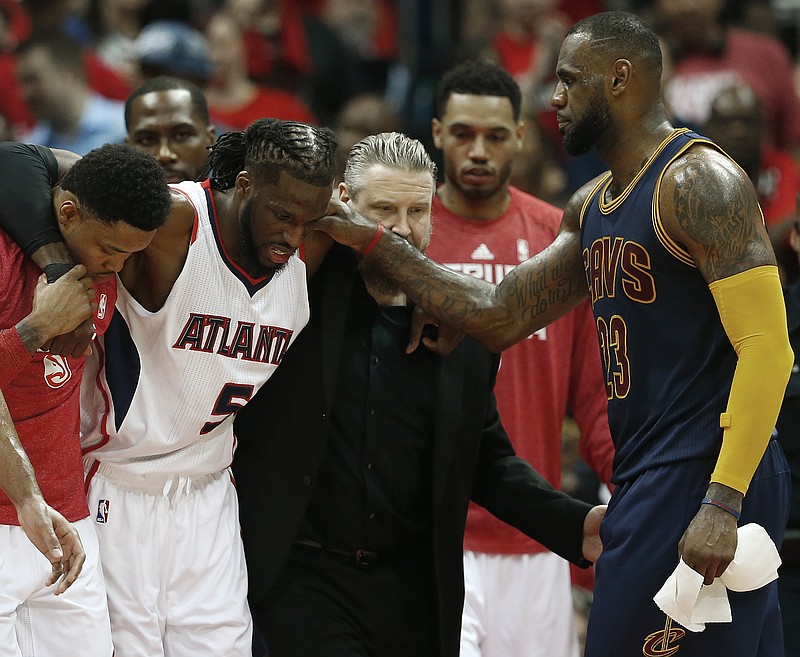 
              Cleveland Cavaliers forward LeBron James, right, speaks with an injured Atlanta Hawks forward DeMarre Carroll (5) as Carroll is helped of the court during the second half in Game 1 of the Eastern Conference finals of the NBA basketball playoffs, Wednesday, May 20, 2015, in Atlanta. (AP Photo/John Bazemore)
            