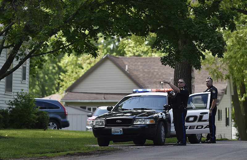 Sedalia police officers are on alert Thursday, May 21, 2015, at a standoff in Sedalia, Mo. where police believe they have a suspect in the slayings of Sandra Sutton and her teenage son Zachary Wade Sutton.