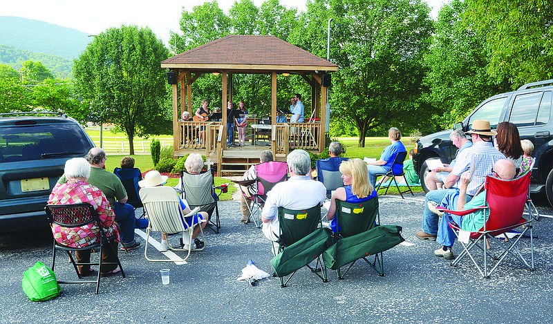 People listen from their cars or while sitting in lawn chairs during a drive-in worship service conducted from a gazebo at Lookout Valley Presbyterian Church.