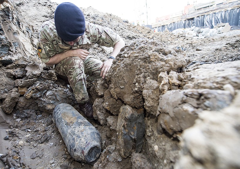 
              An army bomb disposal expert inspects an unexploded World War II bomb found in Wembley, north London, Thursday May 21, 2015. The 50-kilogram (110-pound) bomb was discovered by workers at a construction site near Wembley stadium. It is believed to have been dropped over London during German bombing raids in the early 1940s. (Sergeant Rupert Frere of the Royal Logistic Corrps/MoD Crown Copyright via AP) NO SALES
            