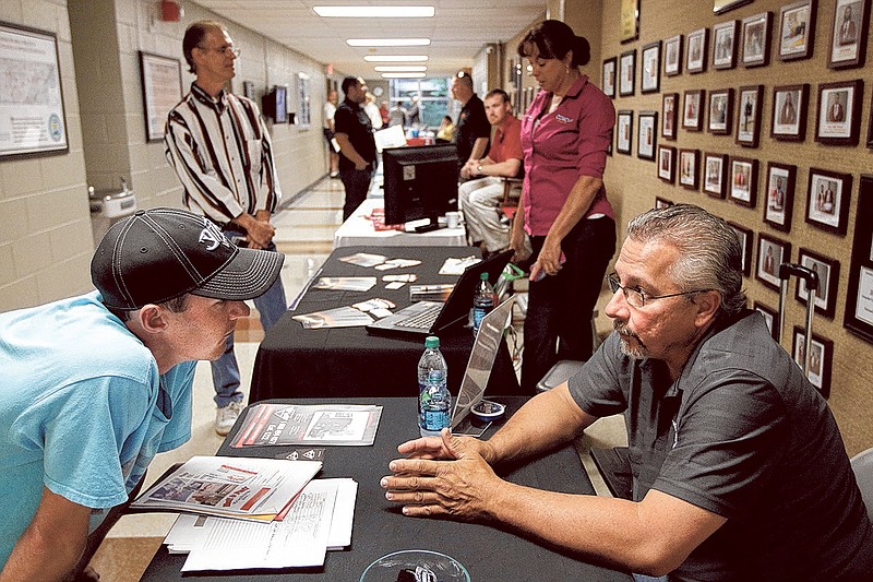 Re West Transportation's Jerry Sabatino, right, talks with trucker Patrick Withrow, 32, at a recent trucking jobs fair at Chattanooga State.