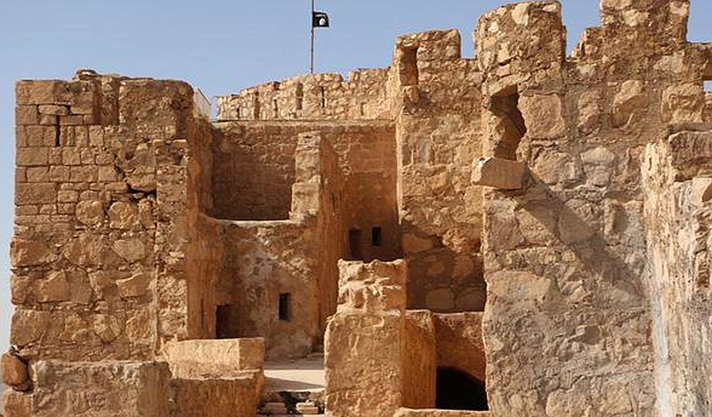 In this picture released on May 22, 2015 by the website of Islamic State militants, shows the Islamic State militants flag, top center, raised on the to top of Palmyra castle, in the Syrian town of Palmyra, Syria. A Syrian official in charge of antiquities says Islamic State fighters have broken into the museum of the ancient town of Palmyra which they have captured days earlier, but have not harmed its contents.