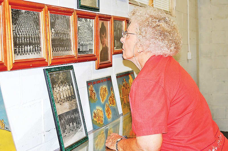A former member of the Women's Army Corps glances at photos in the 6th Cavalry Museum in Fort Oglethorpe during a WAC convention several years ago.
