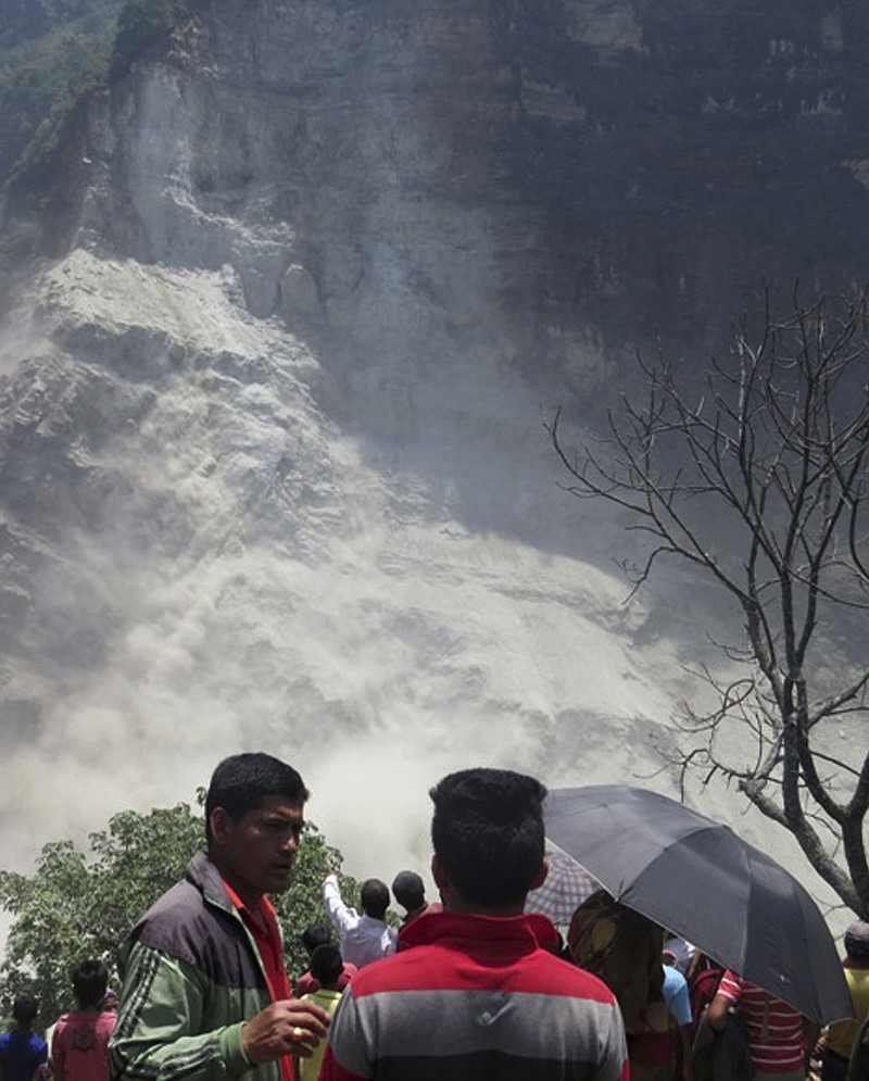 
              People gather at the site of a landslide north of Beni Bazaar, Nepal, Sunday, May 24, 2015. Thousands of people fled villages and towns along a mountain river in northwest Nepal on Sunday after it was blocked by a landslide that could burst and cause flash floods, officials said. (AP Photo/M.B. Astha)
            